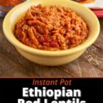 A bowl of misir wat, Ethiopian red lentils, in a yellow bowl, on a wooden table