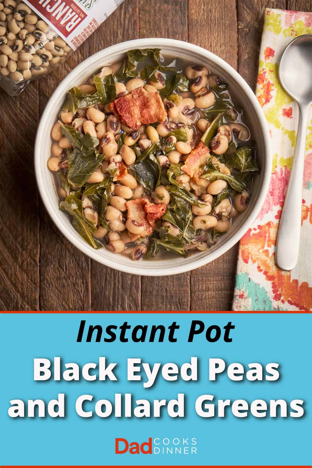 A bowl of black eyed peas and collard greens on a wood table with a bag of beans, a napkin, and a spoon