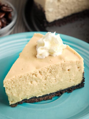 A slice of espresso cheesecake topped with whipped cream