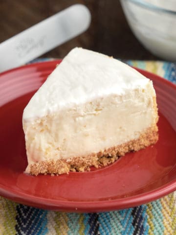 A slice of cheesecake with sour cream topping