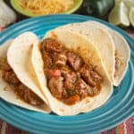 A plate of three carne guisada tacos