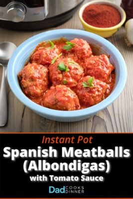 A bowl of Spanish meatballs (Albondigas) in tomato sauce, with a pressure cooker and smoked paprika in the background.