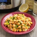 A plate of smashed chickpea and scallion salad, with a lemon, some spices, and an Instant Pot in the background