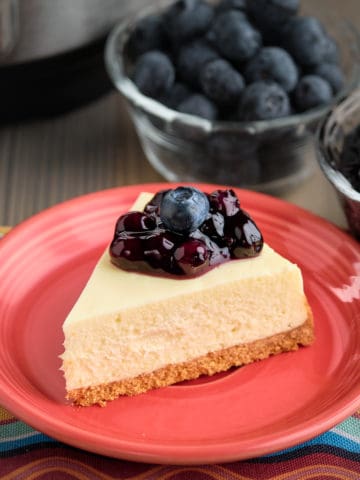 A slice of goat cheese cheesecake topped with blueberries