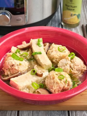 A bowl of sumo soup, with meatballs, tofu, mushrooms, and scallions, with an Instant Pot and Hot Yuzu Sauce in the background