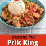 A bowl of prik king pork curry with a scoop of rice, topped with slivered basil and Thai red peppers