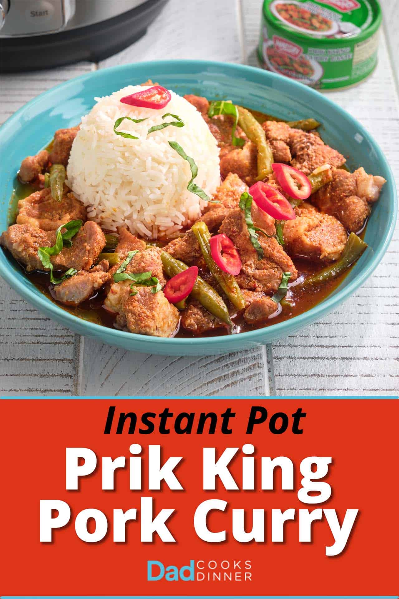 A bowl of prik king pork curry with a scoop of rice, topped with slivered basil and Thai red peppers