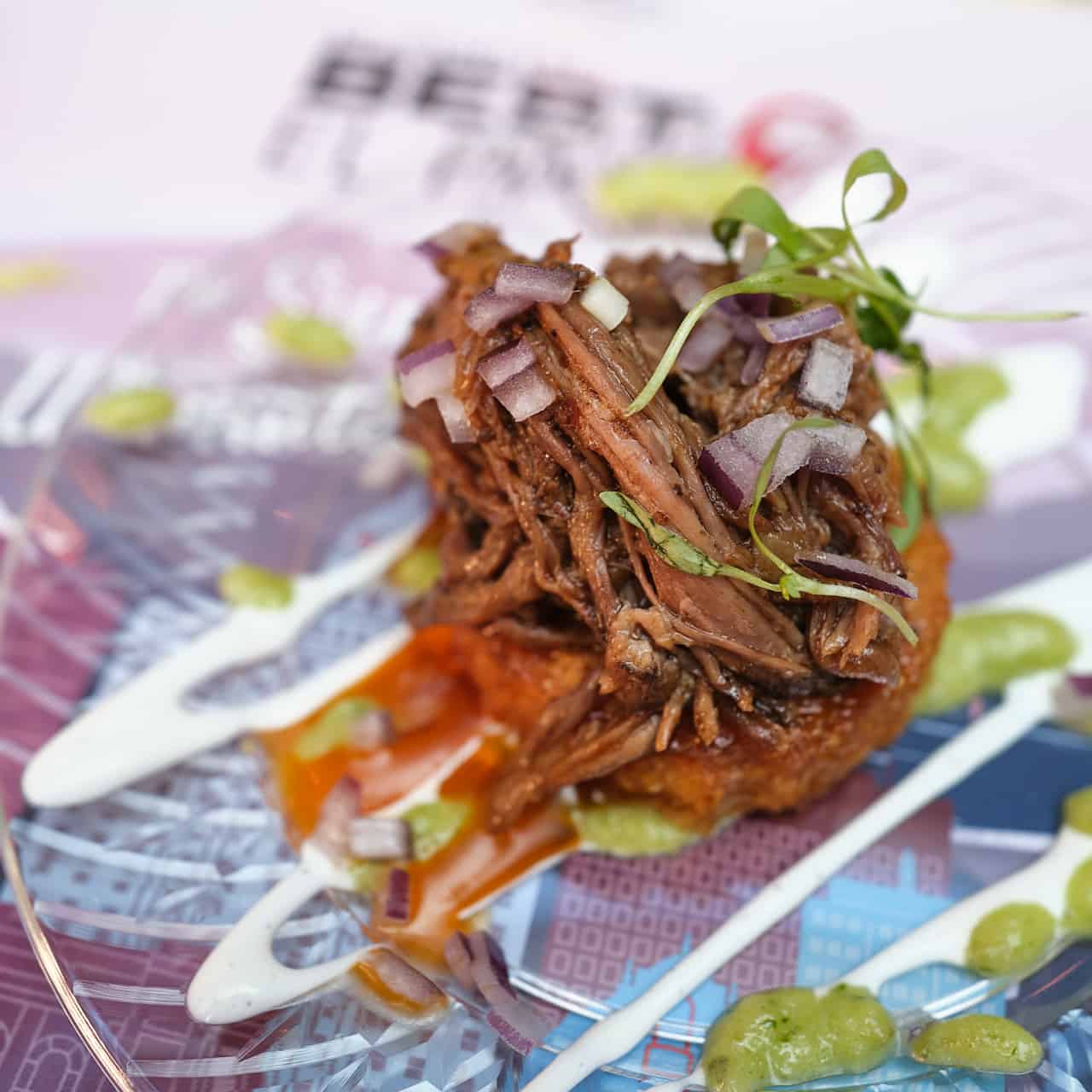 An appetizer of shredded short rib piled on polenta