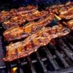 Beef short ribs on the grill, with some flareups in the background