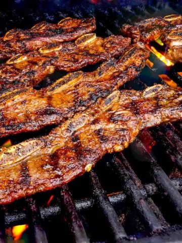 Beef short ribs on the grill, with some flareups in the background