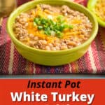 A bowl of white turkey chili with cheese and green onions sprinkled on top