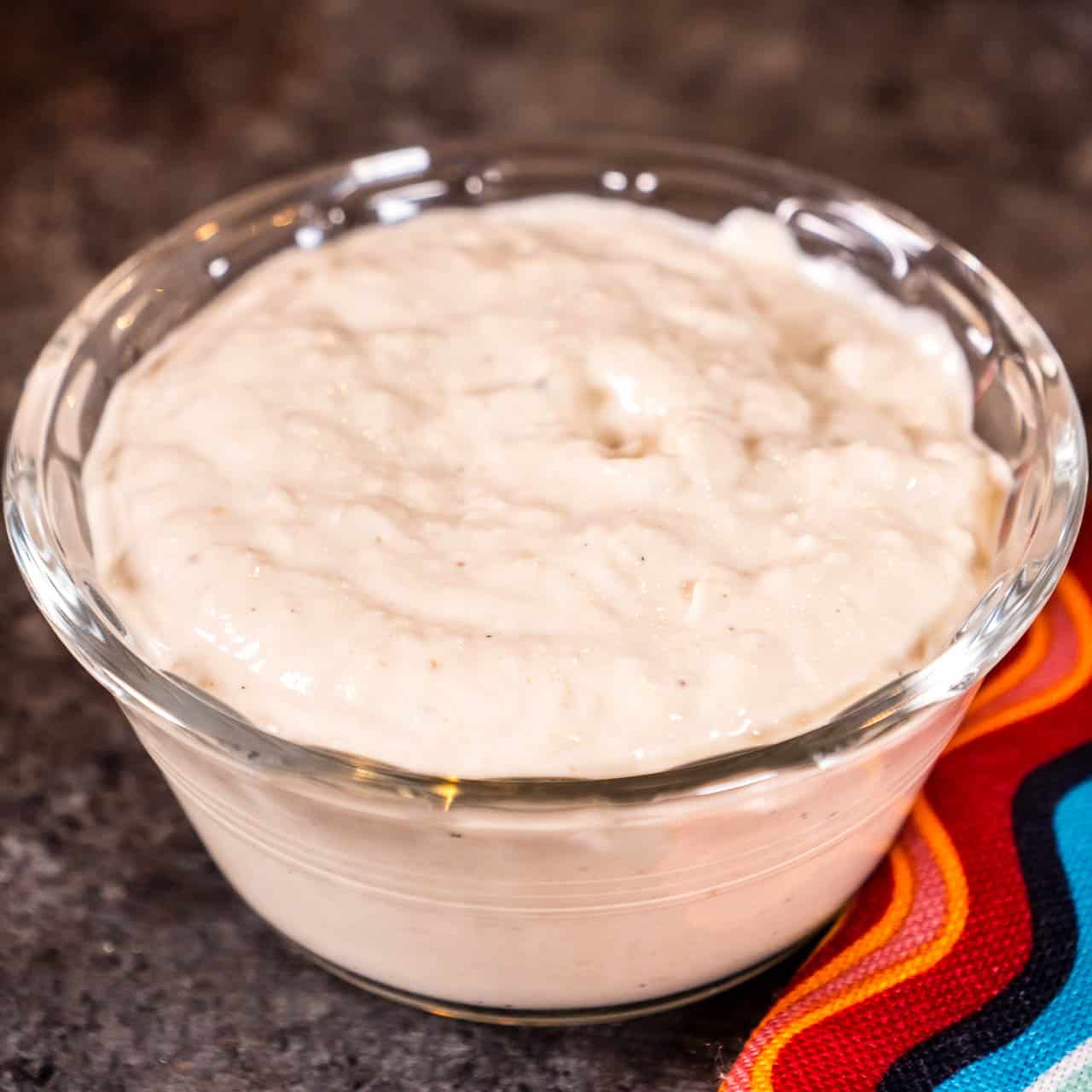 A small bowl of horseradish sauce with a colorful napkin