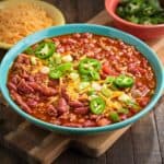 A bowl of 5 ingredient chili, topped with cheese, jalapenos, and green onion
