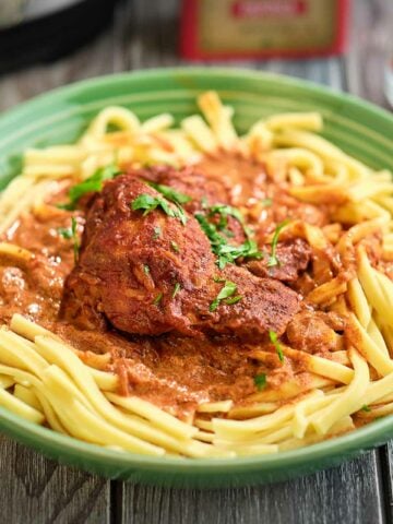 A bowl of chicken paprikash on noodles