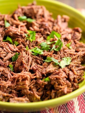 A bowl of shredded beef sprinkled with cilantro