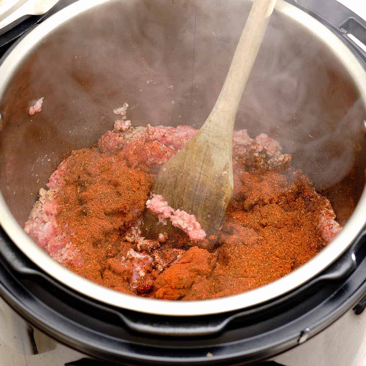 Ground beef and chili powder sauteing in an Instant Pot