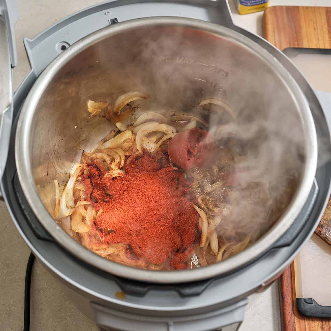 Onions, paprika, and tomato paste in an instant pot