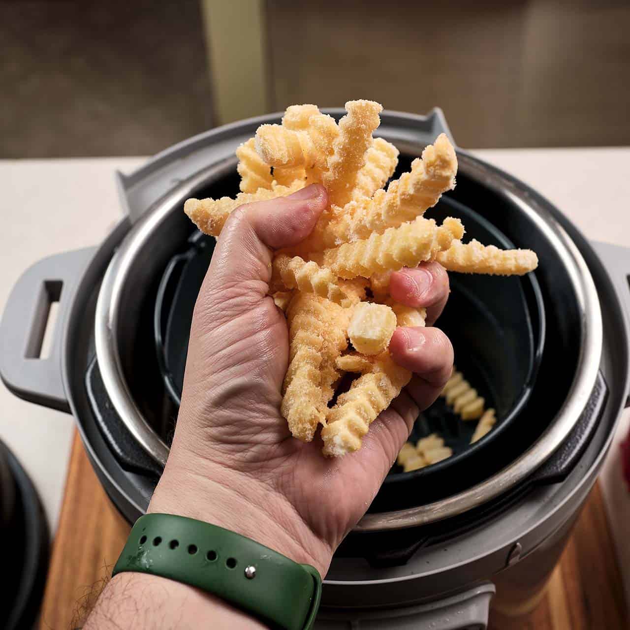 A fistful of frozen french fries