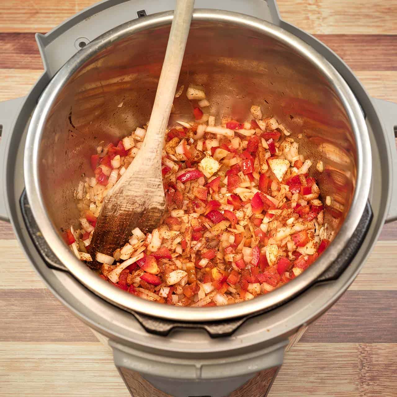 Peppers, onions, garlic, and spices sautéing in an Instant Pot