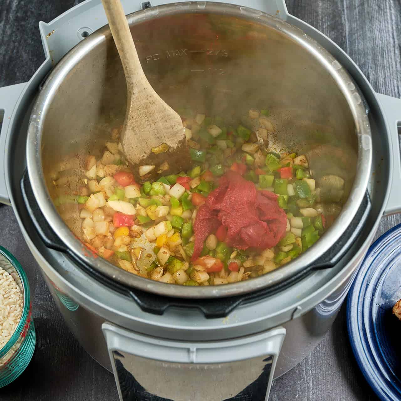 An Instant Pot full of onions, peppers, and tomato paste