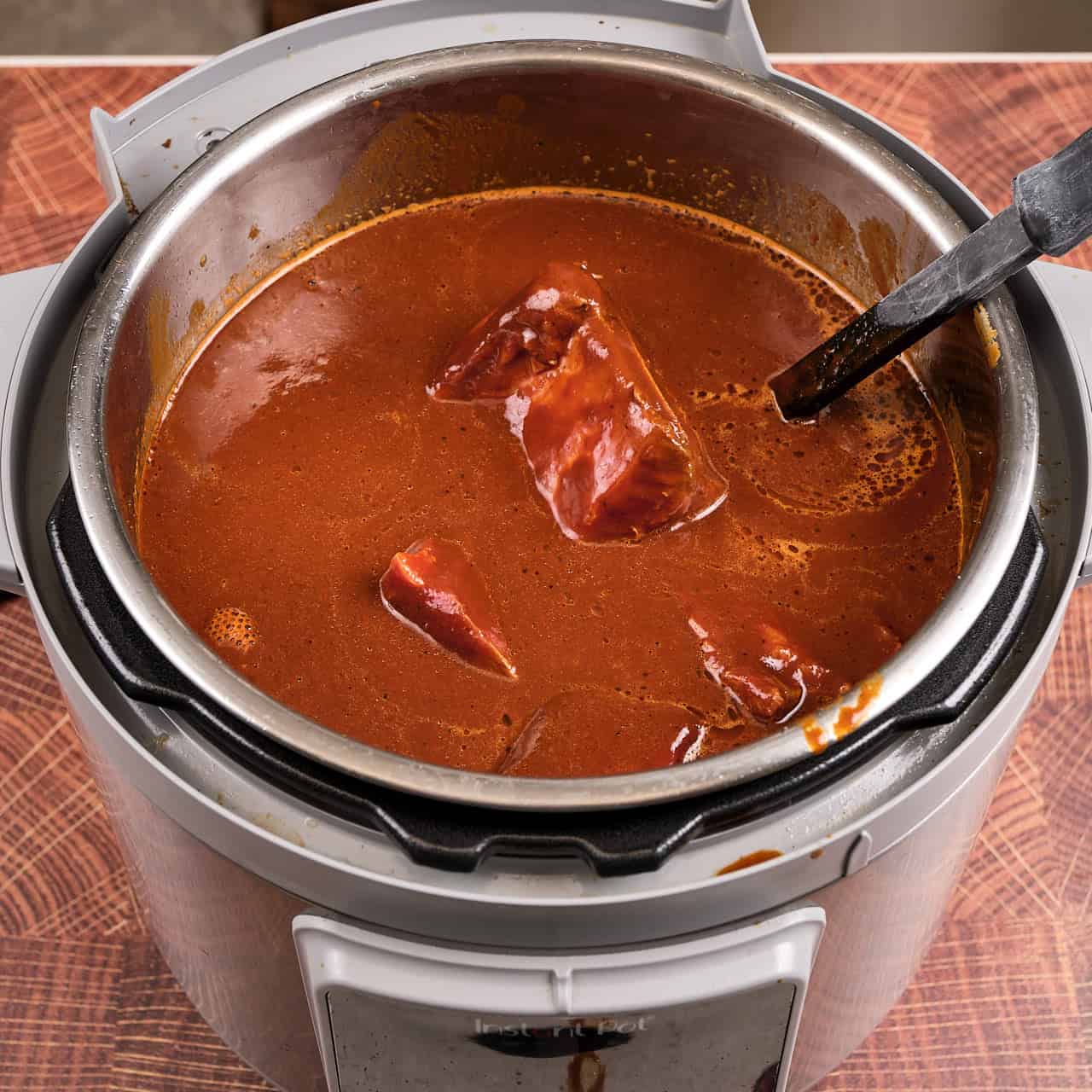 An Instant Pot full of short ribs, adobo, and broth