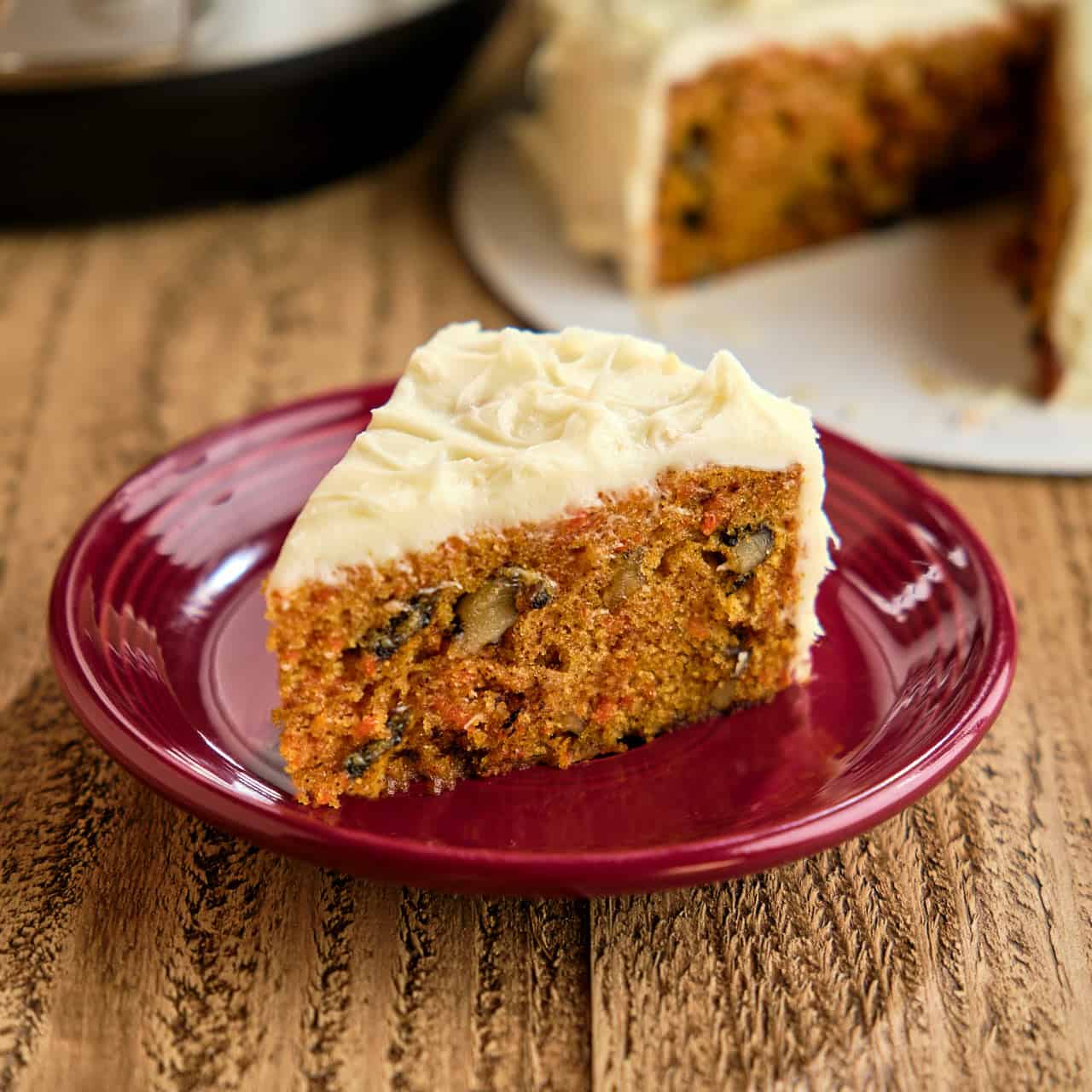 A piece of carrot cake on a purple plate