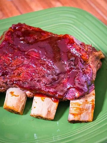 A quarter slab of St. Louis Ribs on a green plate