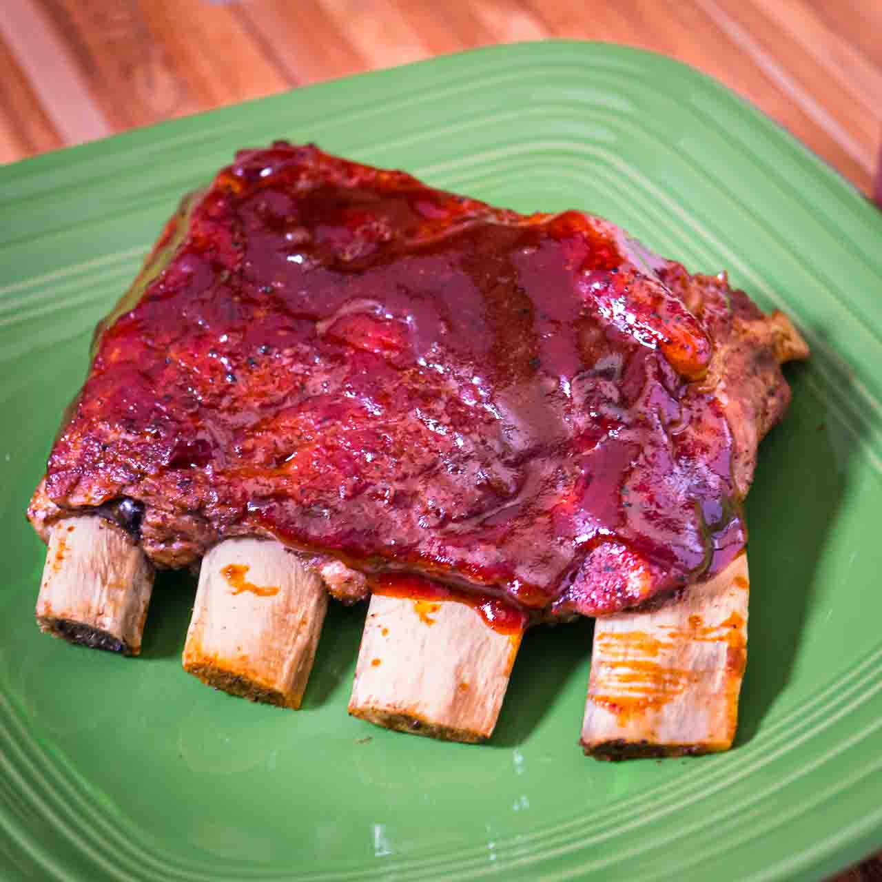 A quarter slab of St. Louis Ribs on a green plate