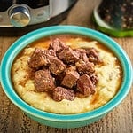 A bowl of beef tips and gravy on mashed potatoes