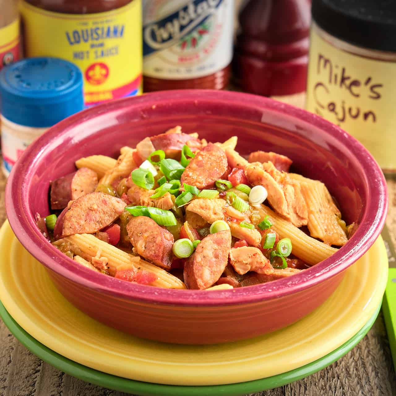 A bowl of Instant Pot Pastalaya with hot sauces and spices