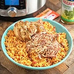 Shredded pork on a bed of rice, with an Instant Pot, jar of Recaito, and Sazon packets