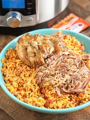 Shredded pork on a bed of rice, with an Instant Pot, jar of Recaito, and Sazon packets