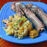 A plate of sauerkraut and pork ribs with mustard