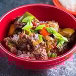 A bowl of Instant Pot Pepper Steak with chopsticks and rice