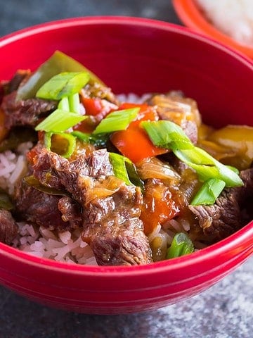 A bowl of Instant Pot Pepper Steak with chopsticks and rice