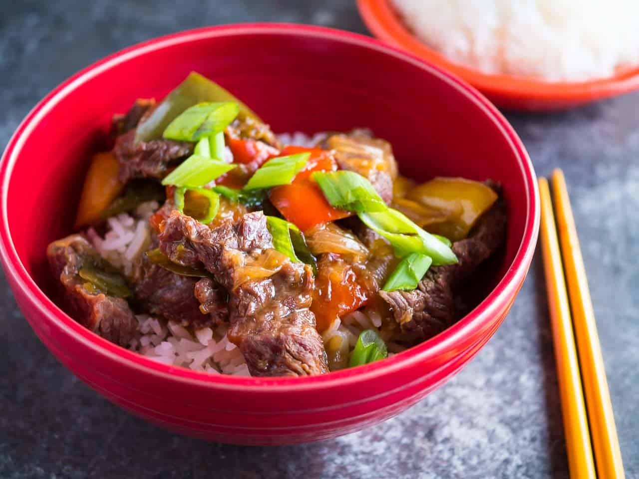 A bowl of Instant Pot Pepper Steak with chopsticks and rice