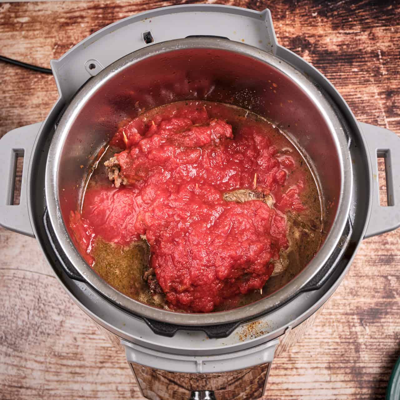 An instant pot full of beef braciole ingredients, ready to lock the lid