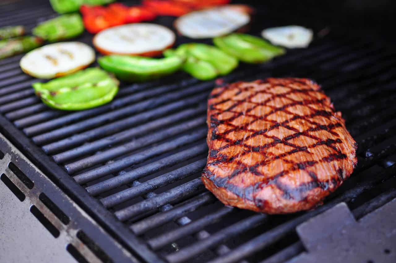 Grilling the flank steak, peppers, and onions