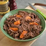 A bowl of shredded sirloin tip roast with carrots