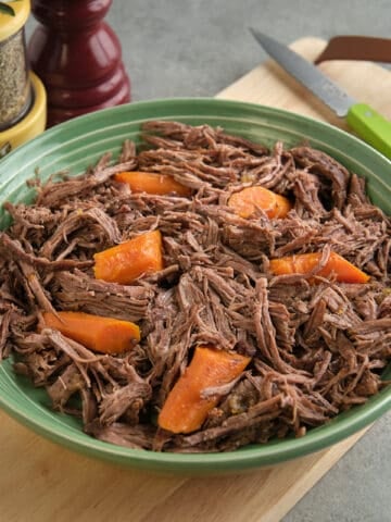 A bowl of shredded sirloin tip roast with carrots