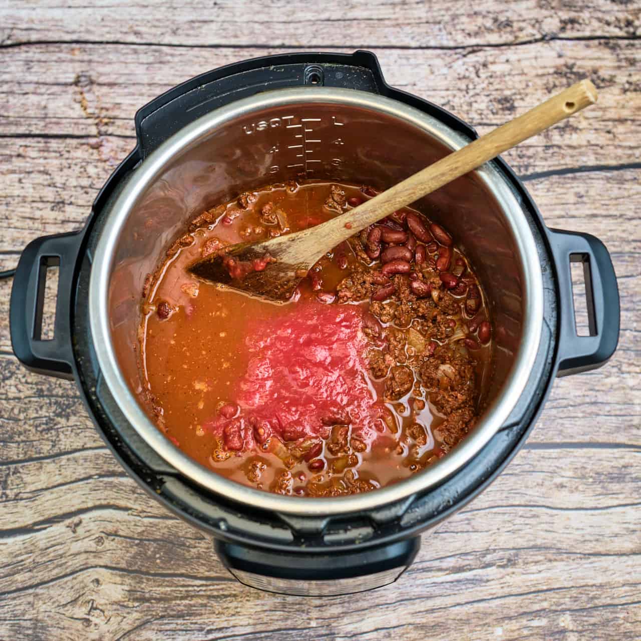 Instant Pot full of Cincinnati chili ingredients, ready to pressure cook