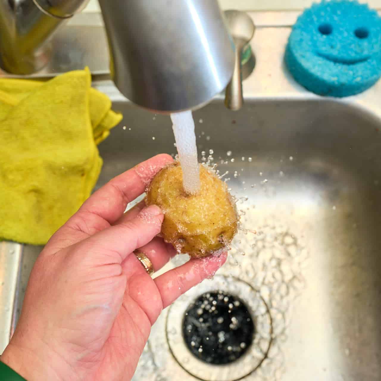 Washing potatoes under cold running water