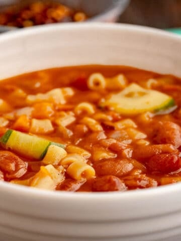 A bowl of minestrone with beans, pasta, and zucchini