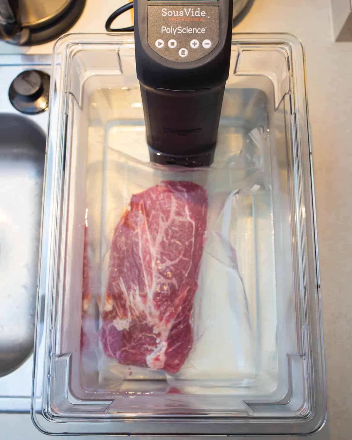 Vacuum sealed flat iron steak in the sous vide water bath tank
