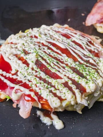 Okonomiyaki - savory Japanese cabbage pancake topped with sauce and kewpie mayo