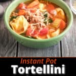 A bowl of tortellini soup with red pepper flakes and a spoon