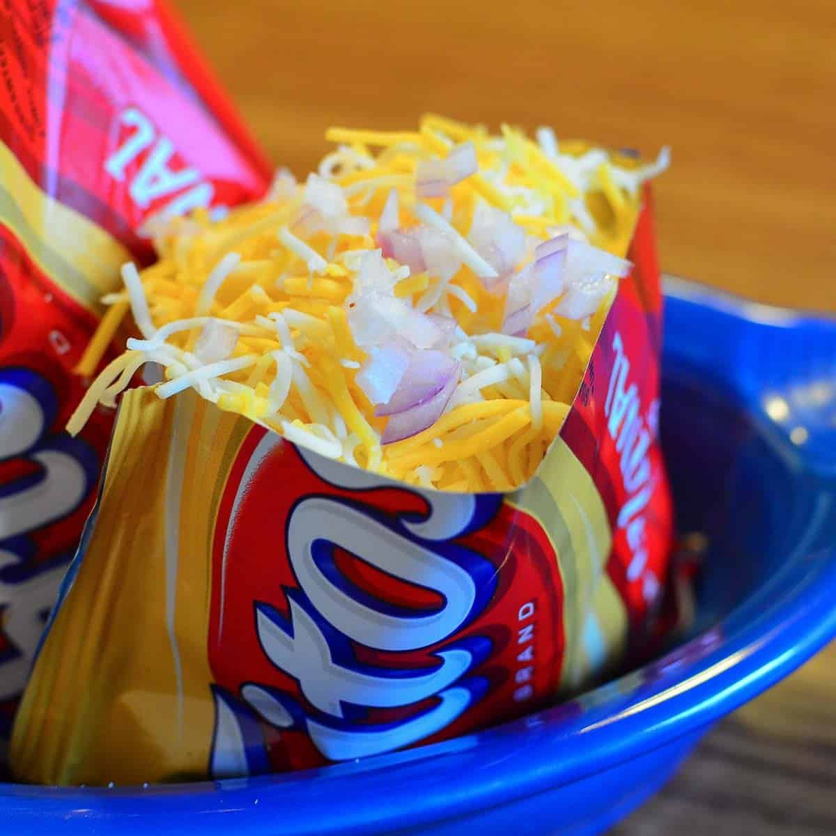Frito pie in a Fritos bag topped with onions