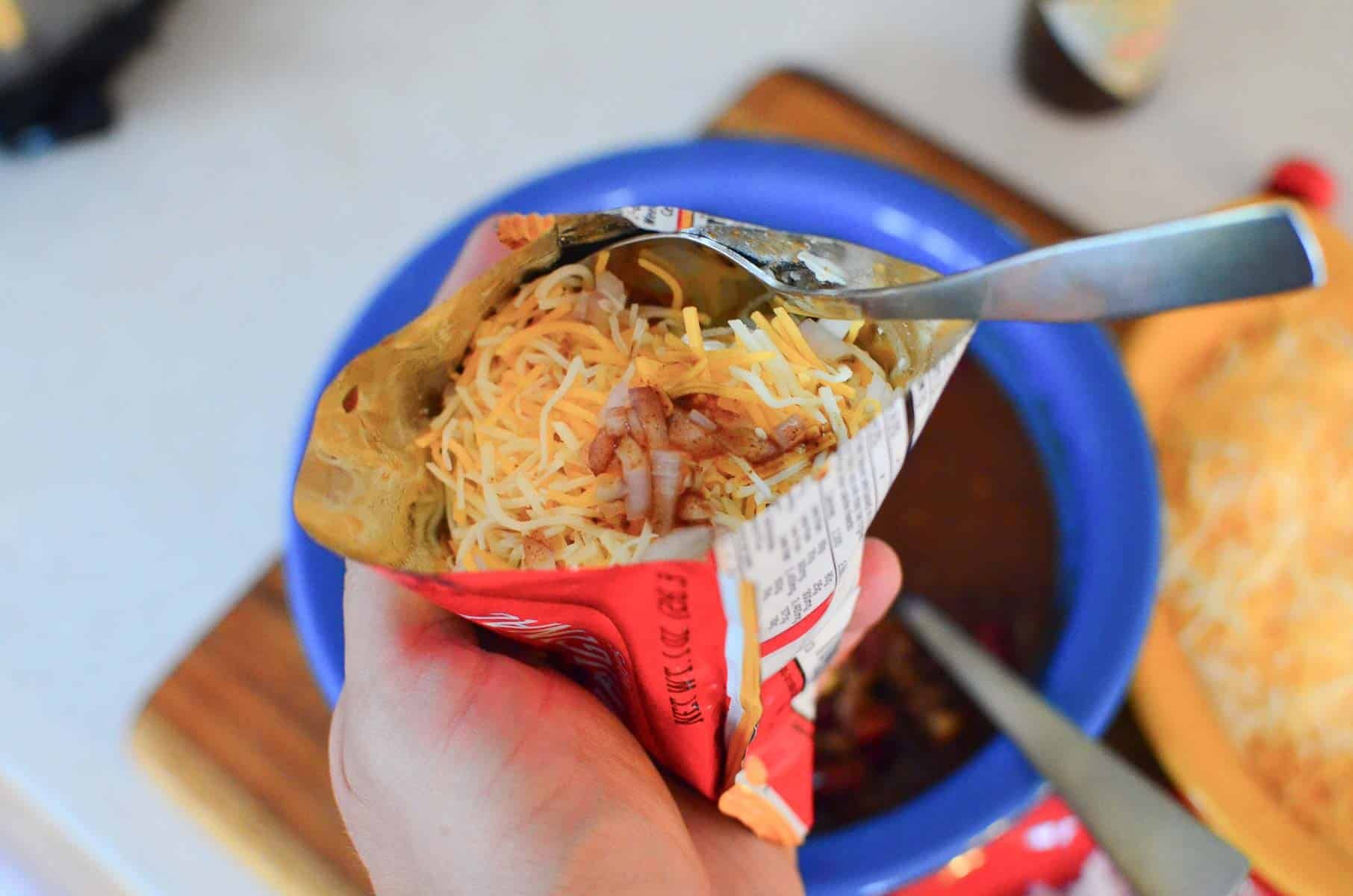 Spoon in the Frito pie bag ready to eat