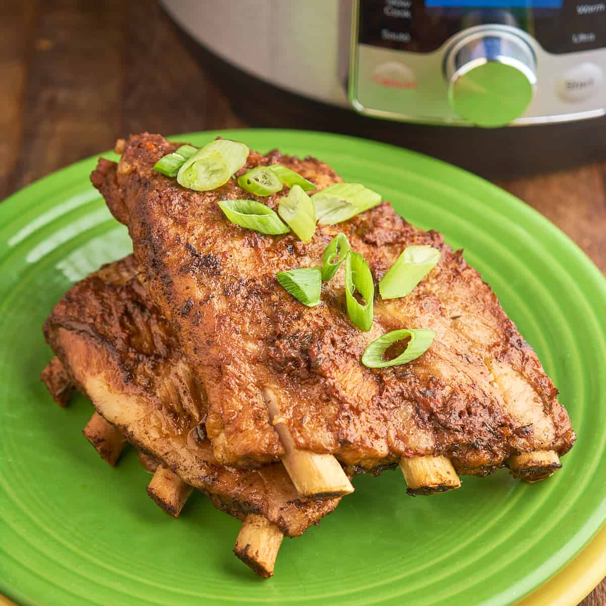 A plate of Instant Pot Jerk Ribs with green onions sprinkled on top