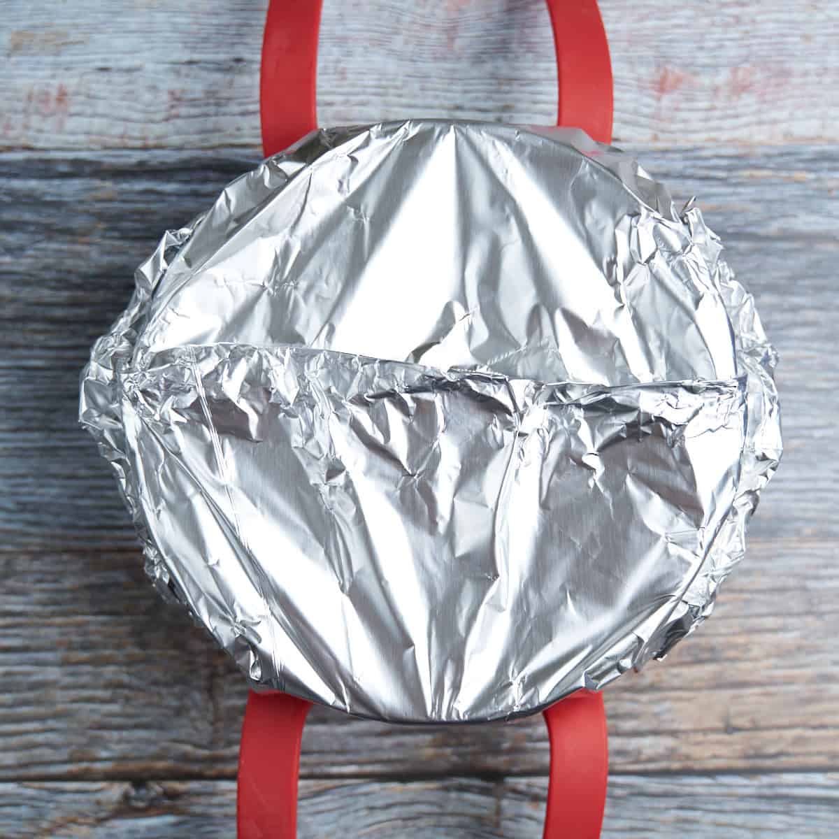 Lasagna pan wrapped in foil and on a baking sling, ready to go into the pot
